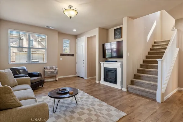 a living room with furniture a fireplace and a flat screen tv
