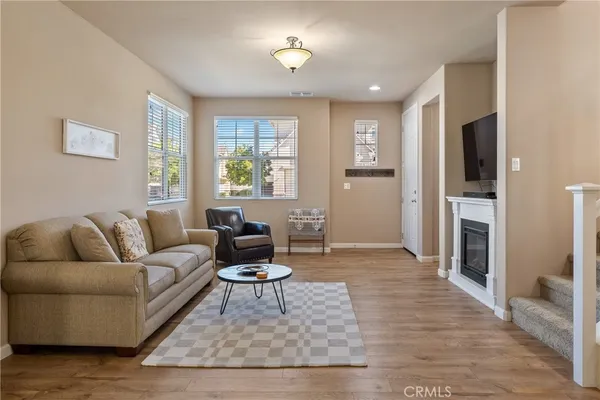 a living room with furniture and a wooden floor
