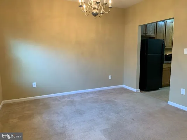 an empty room with a chandelier fan and closet