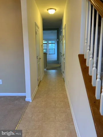 a view of a hallway with wooden floor and stairs