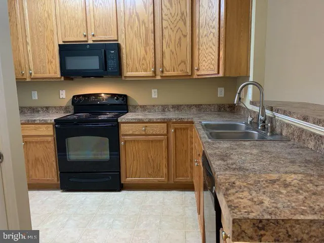 a kitchen with granite countertop a sink and a stove top oven