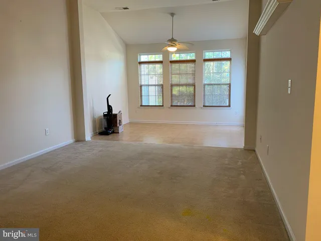 an empty room with windows and chandelier