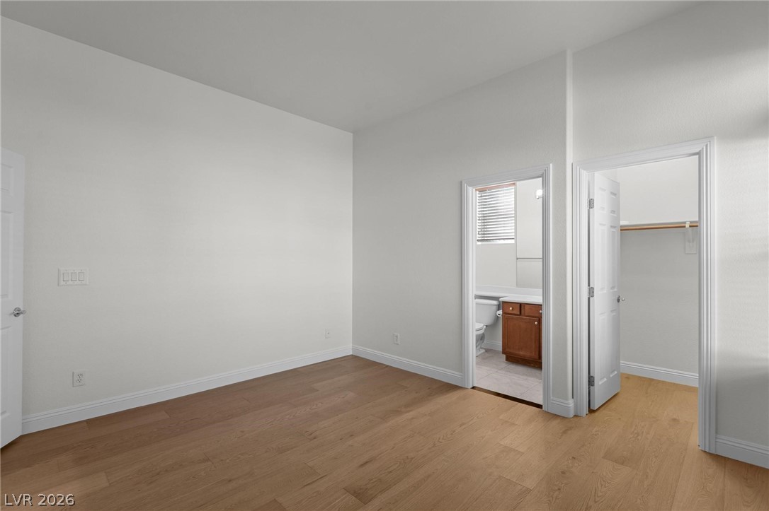 11425 Rancho Portena Avenue Las Vegas, NV 89138 - Photo 17 of 58 Unfurnished bedroom featuring a spacious closet, light wood-style floors, and ensuite bathroom
