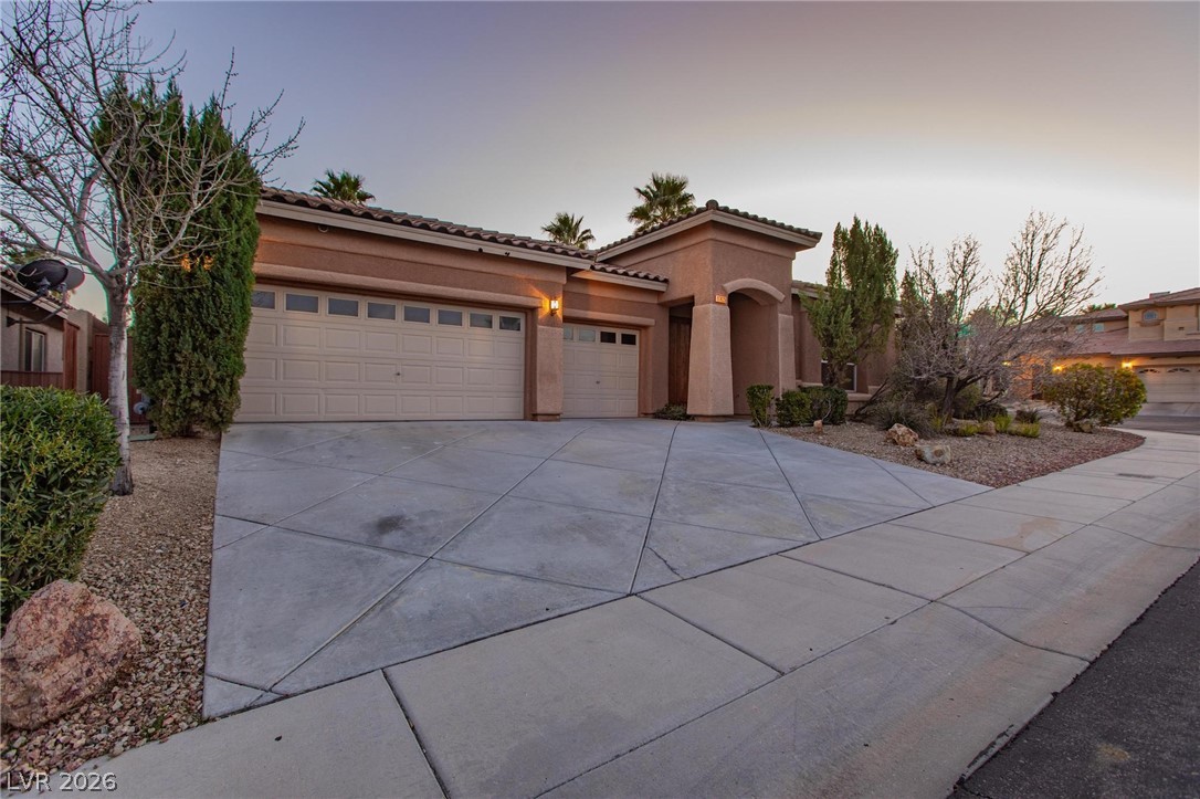 11425 Rancho Portena Avenue Las Vegas, NV 89138 - Photo 3 of 58 View of front of house with driveway, stucco siding, a tile roof, and an attached garage