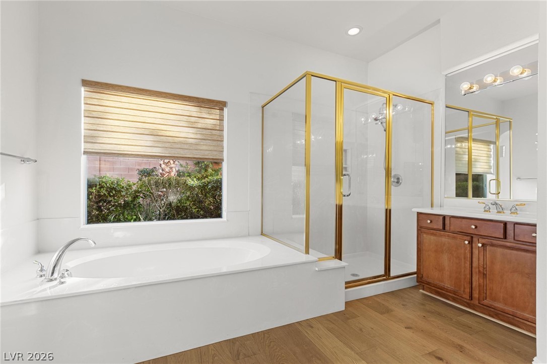 11425 Rancho Portena Avenue Las Vegas, NV 89138 - Photo 34 of 58 Full bathroom with a garden tub, a stall shower, vanity, and light wood-style floors