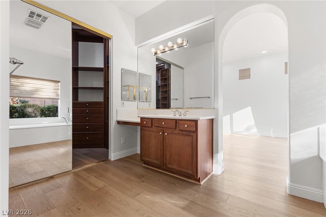 11425 Rancho Portena Avenue Las Vegas, NV 89138 - Photo 35 of 58 Full bath with a freestanding bath, vanity, light wood-type flooring, and a walk in closet