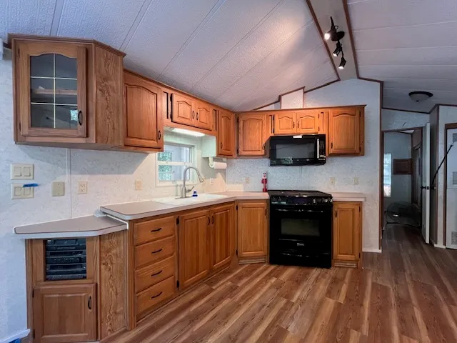 a kitchen with stainless steel appliances granite countertop a stove sink and cabinets