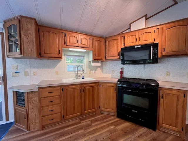 a kitchen with a stove a sink and a microwave