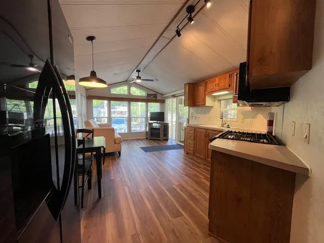 a kitchen with stainless steel appliances granite countertop wooden floors stove top oven and sink