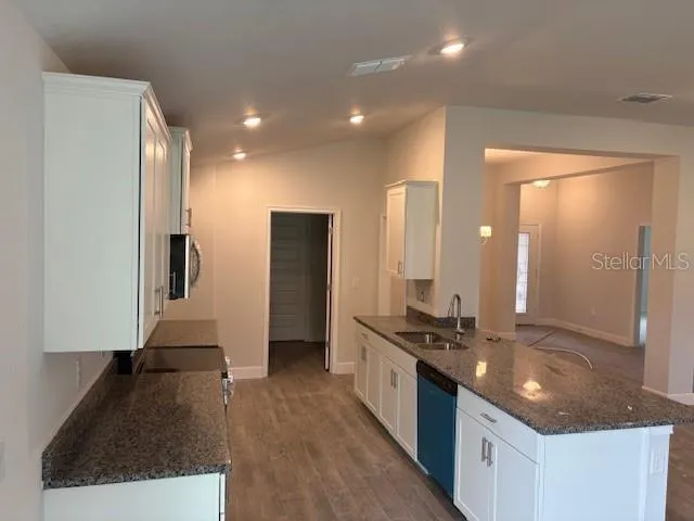 a kitchen with stainless steel appliances granite countertop a sink and a refrigerator