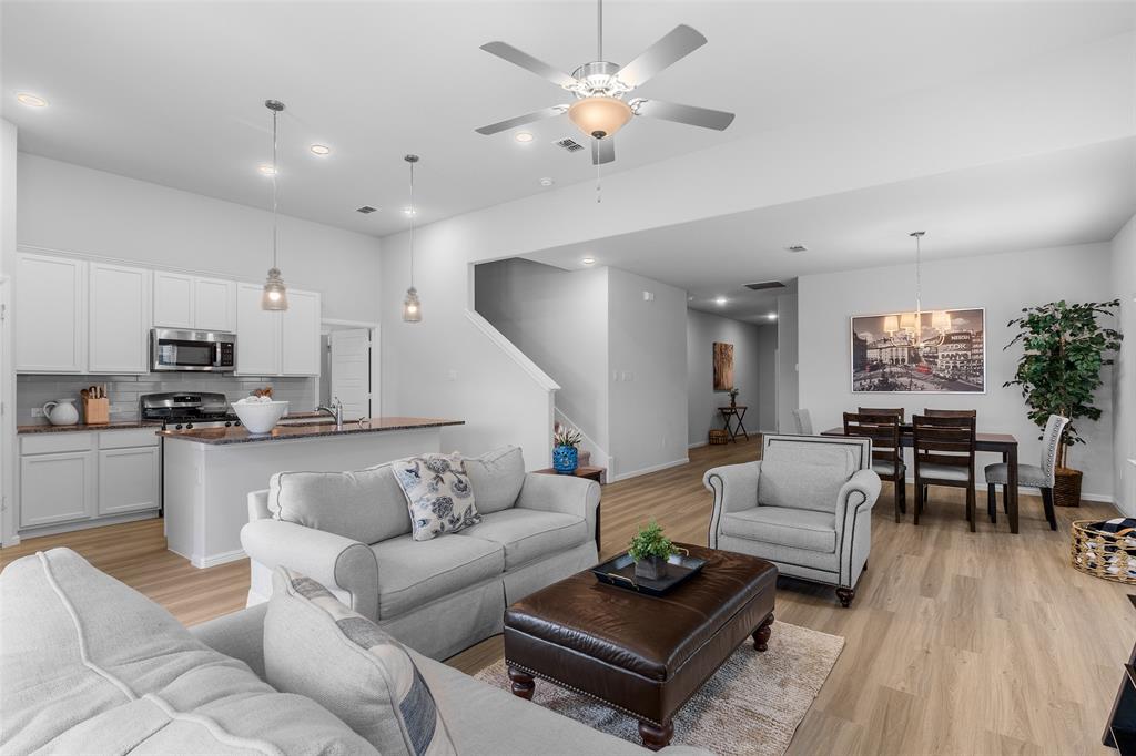 a living room with furniture kitchen view and a chandelier