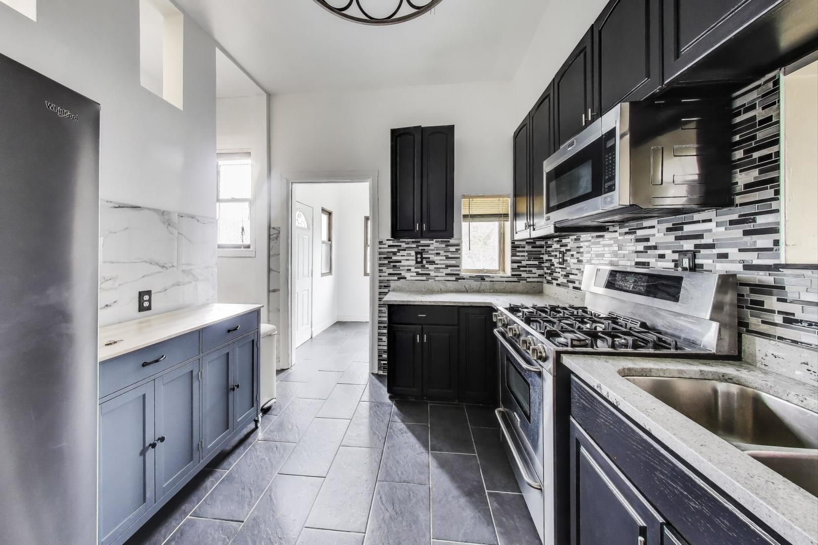 928 East 46th Street Chicago, IL 60653 - Photo 12 of 28 a kitchen with stainless steel appliances granite countertop a sink stove and refrigerator
