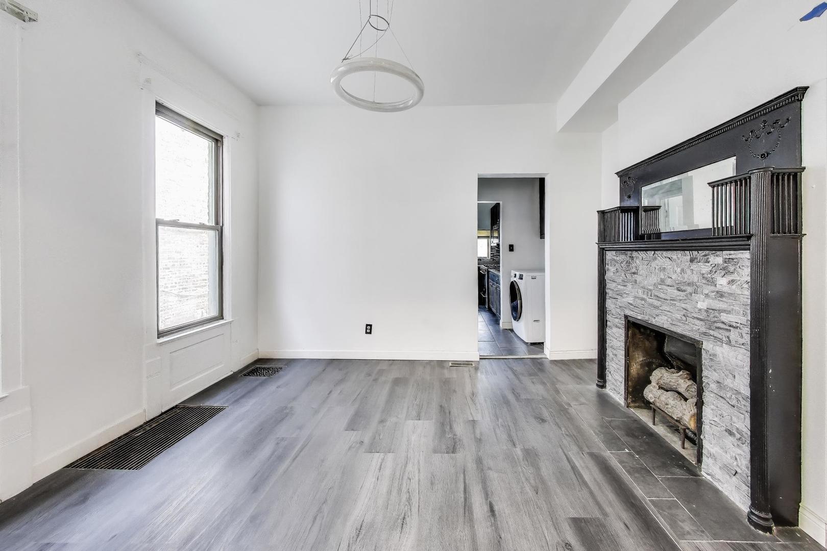 928 East 46th Street Chicago, IL 60653 - Photo 8 of 28 a view of empty room with wooden floor and fireplace