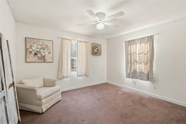 an empty room with a ceiling fan and a window