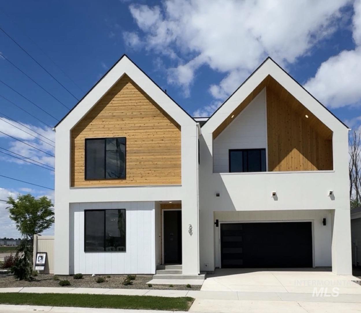 29 North Feather Reed Avenue Meridian, ID 83642 - Photo 1 of 1 Modern architectural exterior featuring white stucco, natural wood-finish siding, and prominent gabled rooflines