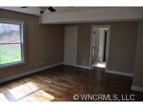 305 Nottingham Road Maggie Valley, NC 28751 - Photo 2 of 10 a view of an empty room with wooden floor and a window