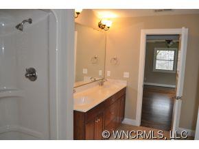 305 Nottingham Road Maggie Valley, NC 28751 - Photo 6 of 10 a bathroom with a granite countertop sink a mirror and a shower