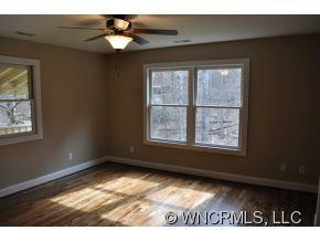 305 Nottingham Road Maggie Valley, NC 28751 - Photo 8 of 10 a view of an empty room with wooden floor and a window