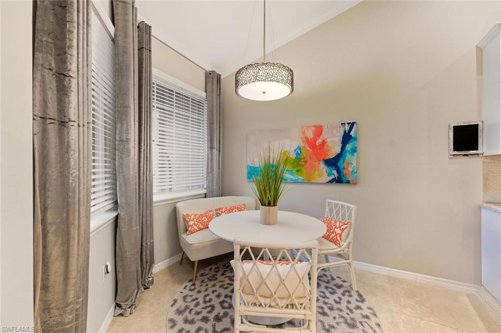 9365 Pocida Court, Unit 202 Naples, FL 34119 - Photo 17 of 40 a view of a dining room with furniture and wooden floor