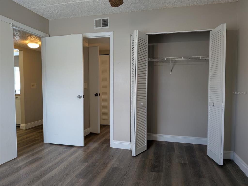 5613 Blue Shadows Court, Unit 2 Orlando, FL 32811 - Photo 14 of 26 an empty room with wooden floor and closet