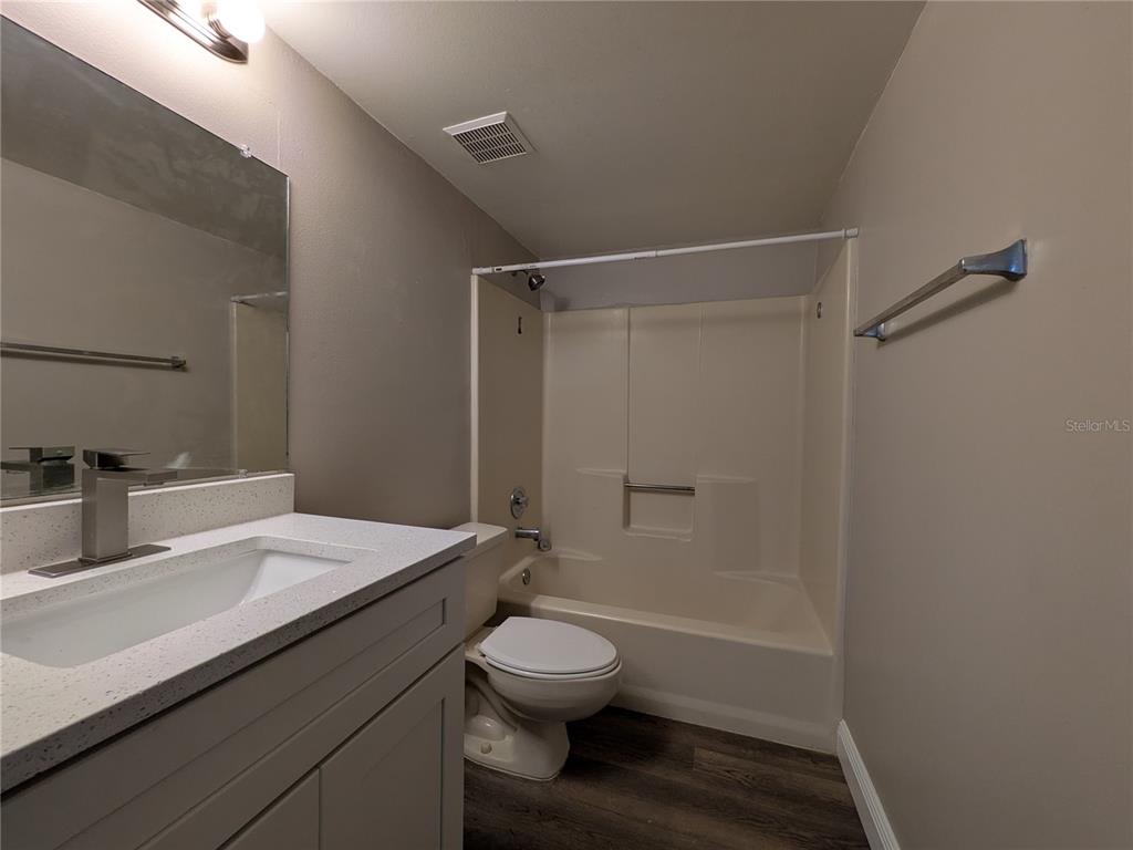 5613 Blue Shadows Court, Unit 2 Orlando, FL 32811 - Photo 15 of 26 a bathroom with a sink a toilet and shower