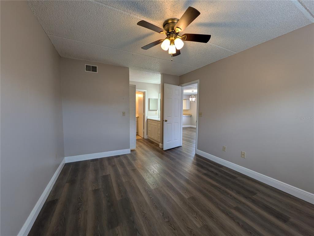 5613 Blue Shadows Court, Unit 2 Orlando, FL 32811 - Photo 17 of 26 an empty room with a hardwood and ceiling fan