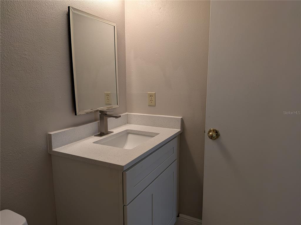 5613 Blue Shadows Court, Unit 2 Orlando, FL 32811 - Photo 20 of 26 a bathroom with a sink and a mirror