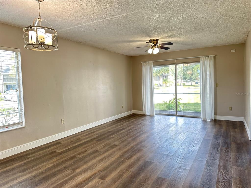 5613 Blue Shadows Court, Unit 2 Orlando, FL 32811 - Photo 8 of 26 a view of an empty room with wooden floor and a window