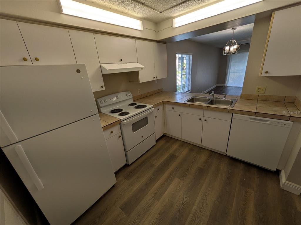 5613 Blue Shadows Court, Unit 2 Orlando, FL 32811 - Photo 10 of 26 a kitchen with cabinets a sink and appliances