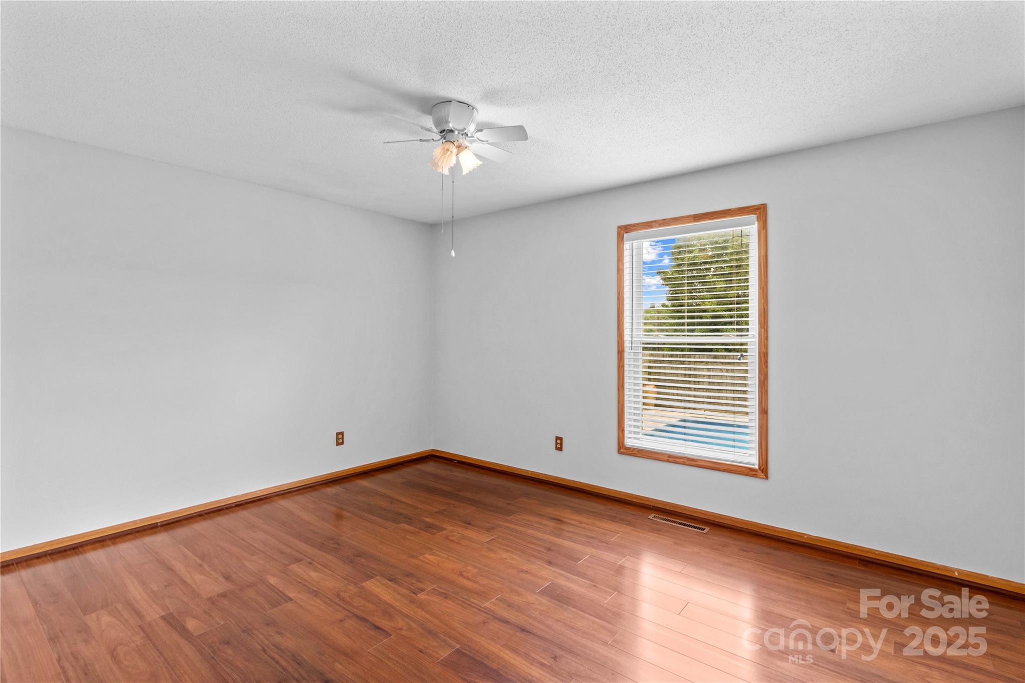 296 Hicks Creek Road Troutman, NC 28166 - Photo 20 of 48 an empty room with wooden floor and windows