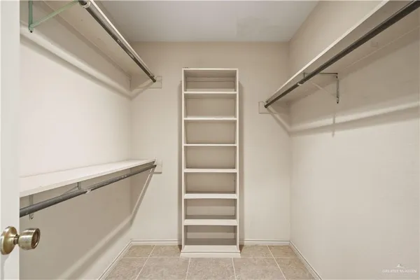 a view of walk in closet with empty racks