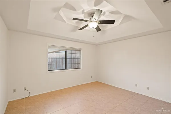 an empty room with a window and a fan