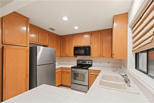 a kitchen with granite countertop a refrigerator stove and microwave