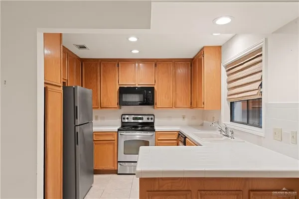 a kitchen with granite countertop a refrigerator stove and sink