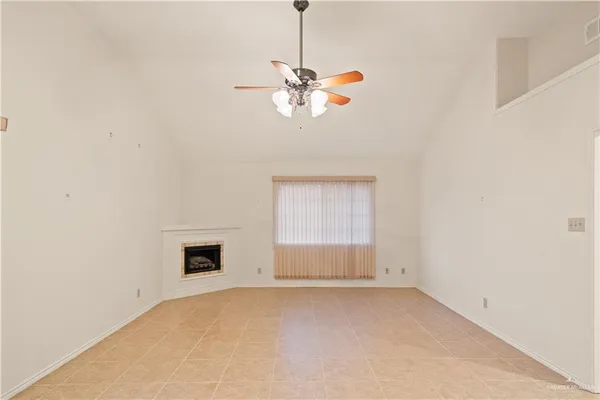 a view of a room with a chandelier fan and a window