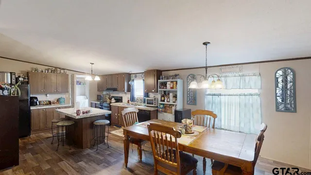 a dining room with furniture a chandelier and wooden floor