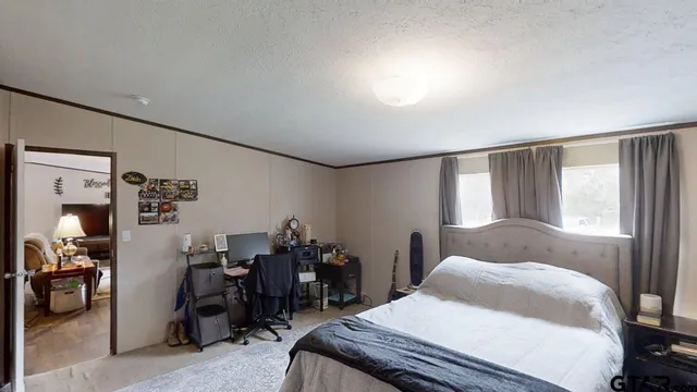 a bedroom with a bed and a large window