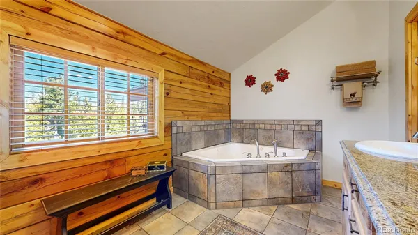 a bathroom with a tub a sink and a potted plant