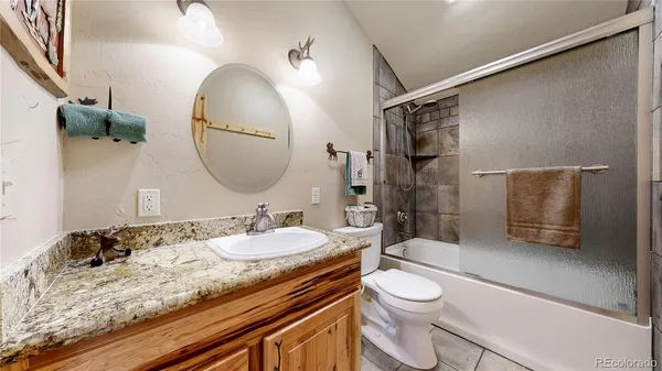 a bathroom with a granite countertop sink toilet and shower