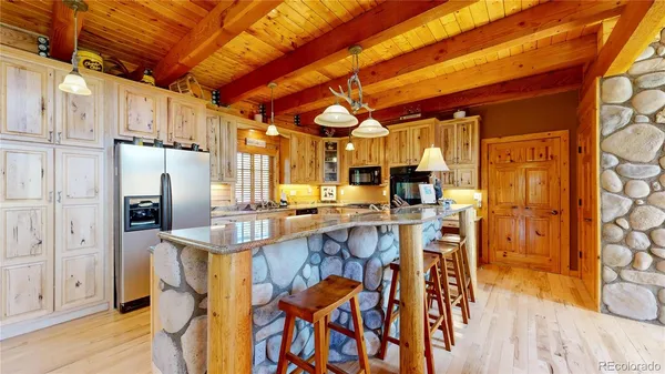a kitchen with stainless steel appliances granite countertop a table chairs and a chandelier