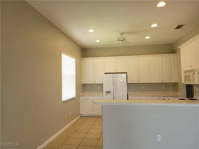 a kitchen with kitchen island white cabinets and white appliances