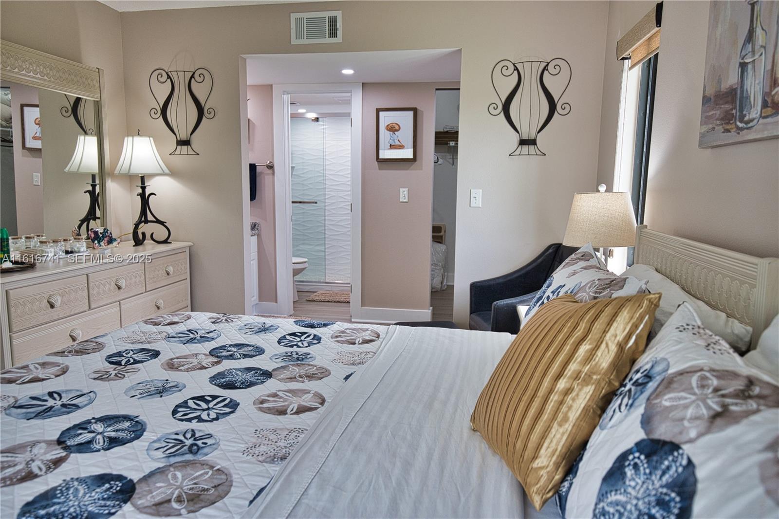2810 North Beach Road, Unit D108 Englewood, FL 34223 - Photo 15 of 44 a bedroom with a bed and dresser with mirror