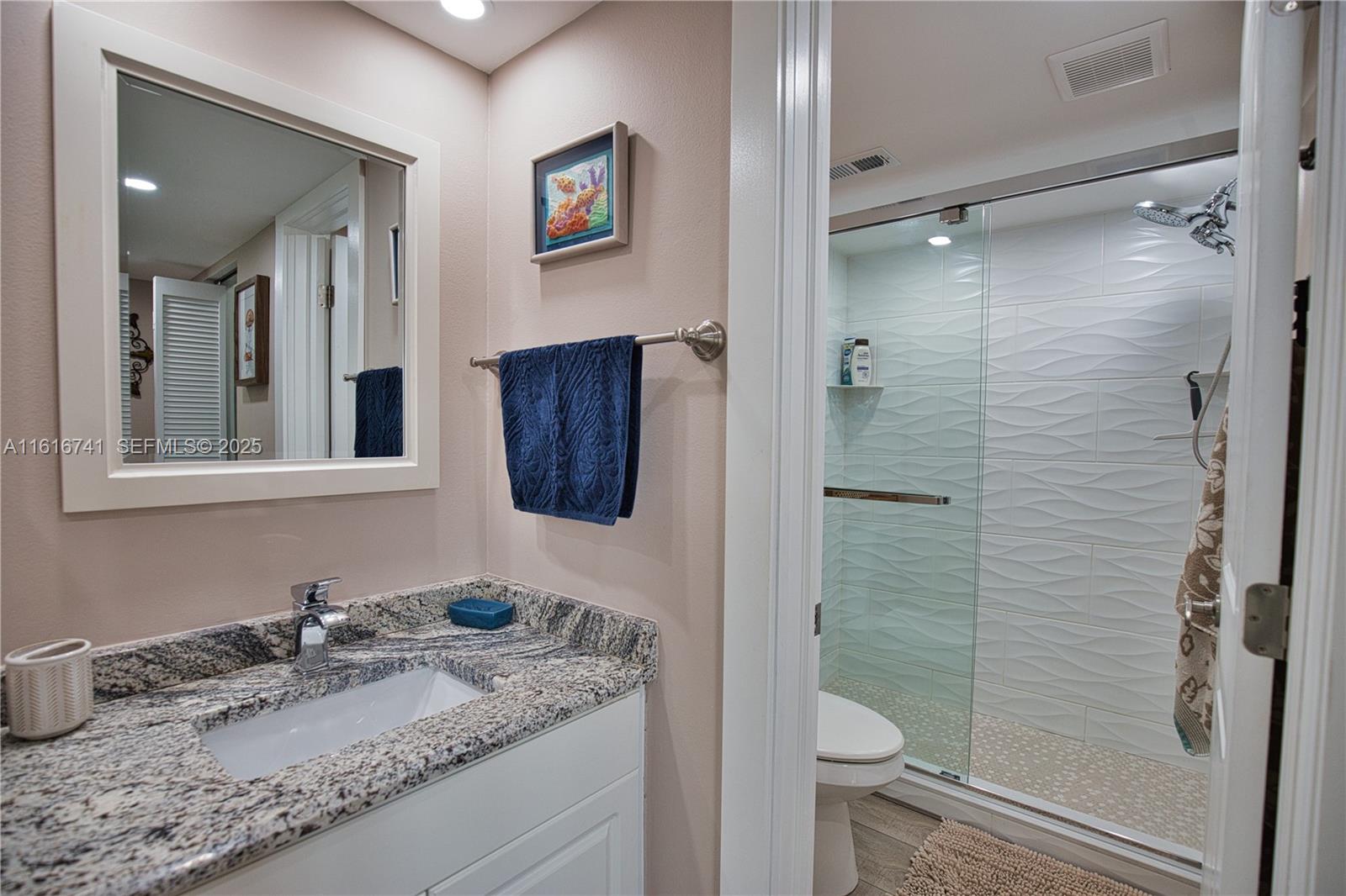2810 North Beach Road, Unit D108 Englewood, FL 34223 - Photo 18 of 44 a bathroom with a granite countertop sink toilet and shower