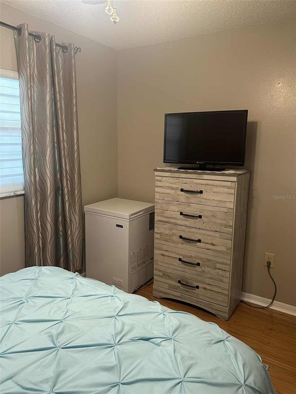 12900 Vonn Road, Unit B202 Largo, FL 33774 - Photo 14 of 23 a bedroom with a bed and a television
