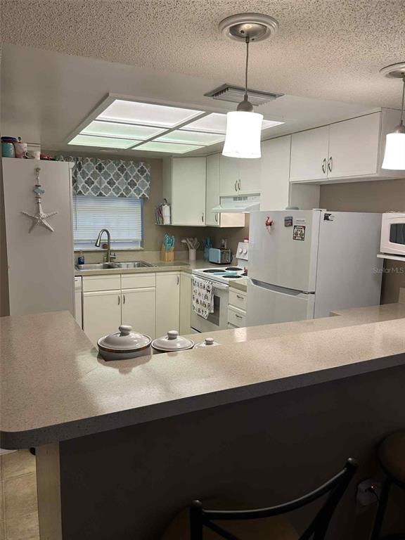 12900 Vonn Road, Unit B202 Largo, FL 33774 - Photo 7 of 23 a kitchen with kitchen island stainless steel appliances a sink and wooden floor