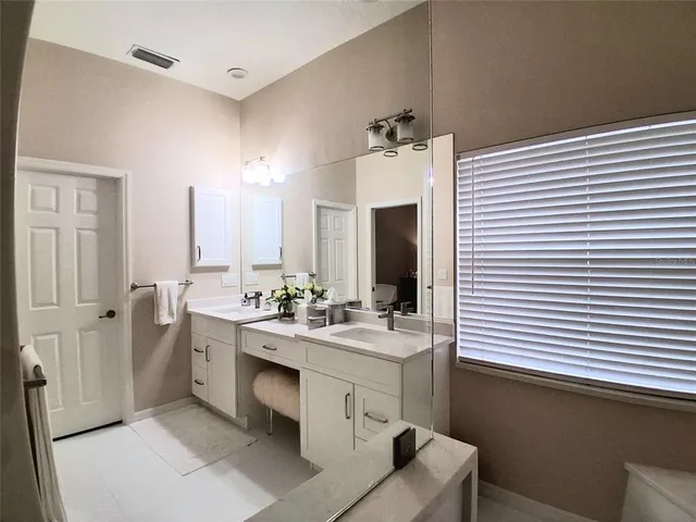 a bathroom with a double vanity sink and mirror