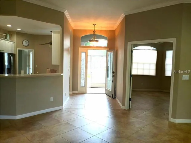 a view of a hallway with wooden floor and a living room