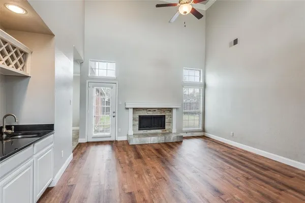 wooden floor fireplace and windows in an empty room