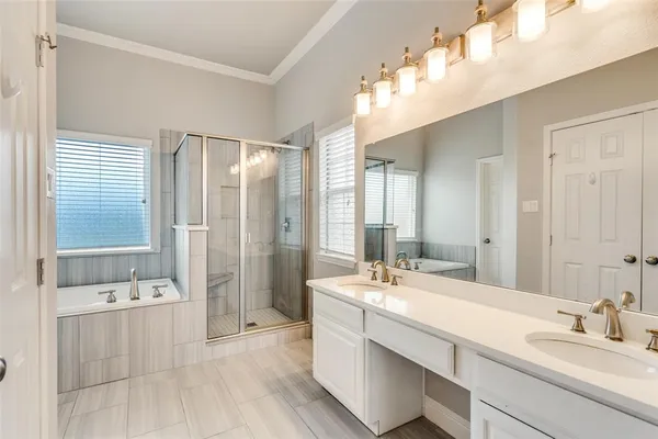 a bathroom with a double vanity sink a mirror and a bathtub