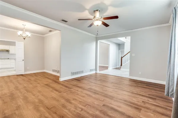 a view of an empty room with a chandelier fan
